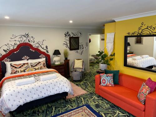 莫斯谷Highlands Riad的一间卧室配有一张床、镜子和一张沙发