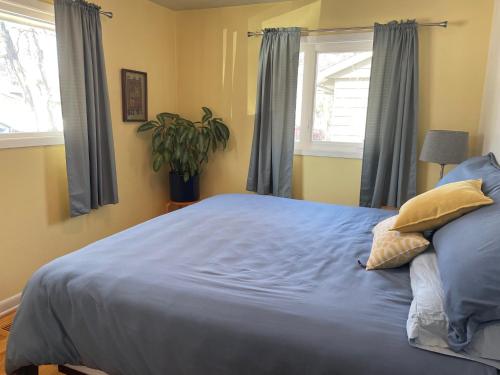 安克雷奇Turnagain Guest House的一间卧室配有一张带蓝色床单和窗户的大床。