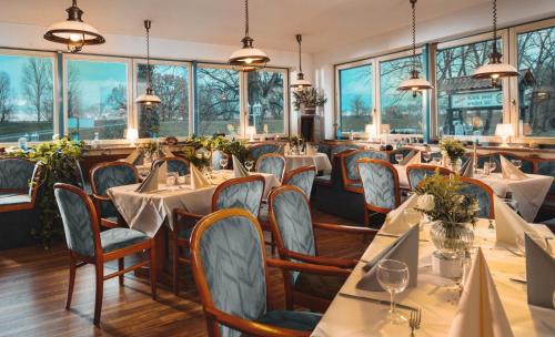德拉格祖尔赛车道酒店的餐厅设有桌椅和窗户。
