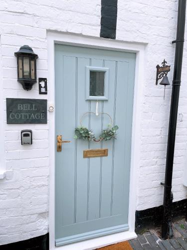 布里奇诺斯Bell Cottage right in the heart of Bridgnorth的白色建筑上带标志的蓝色门