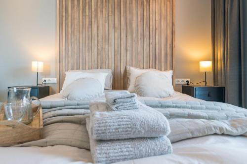 诺德克豪特Luxe appartement dichtbij strand en zee, in het hart van de bollenstreek的一间卧室配有两张带毛巾的床