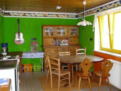 ZiemetshausenSonnenhof in Ziemetshausen bei Legoland Günzburg的厨房设有绿色的墙壁和一张木桌及椅子