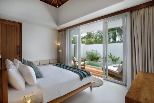 龙目岛库塔Neptune Studios Lombok的一间带特大号床的卧室和一个阳台