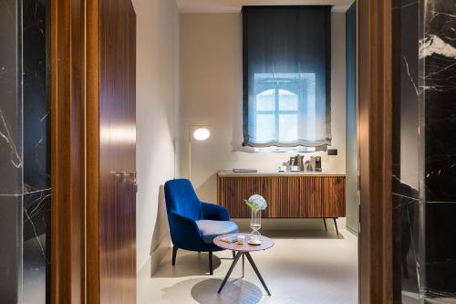 锡拉库扎Byssus Suites的一间设有蓝色椅子和一张桌子的房间