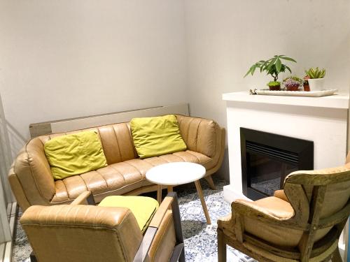 台北斯格加旅店的客厅配有沙发、椅子和壁炉