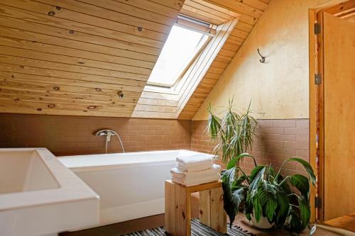 帕维洛斯塔天堂风酒店的浴室配有白色浴缸和天窗。