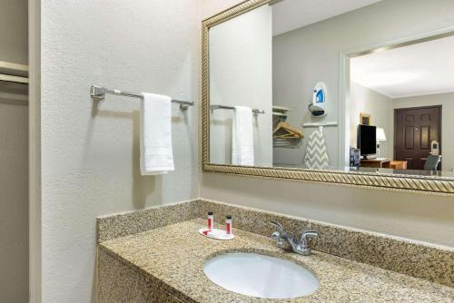 堪萨斯城Super 8 by Wyndham Kansas City Airport North的一间带水槽和镜子的浴室