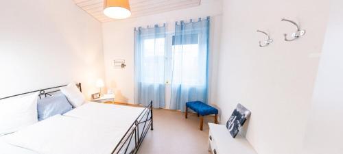 Uznach贝恩特赛住宿加早餐旅馆的一间卧室配有两张床和一张蓝色椅子
