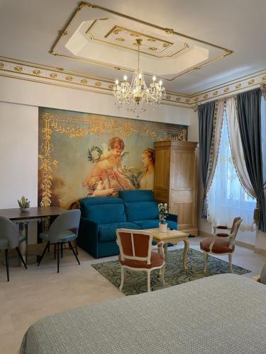 纳博讷Chambre Familiale Maison de L'Église du Couvent的客厅配有蓝色沙发和绘画作品