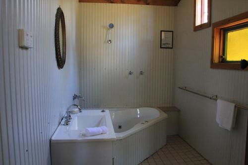 勒弗戴尔Lovedale Cottages Hunter Valley的白色的浴室设有浴缸和水槽。