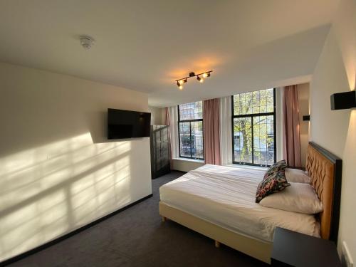 代尔夫特Hotel Bridges House Delft的一间卧室配有一张床和一台平面电视