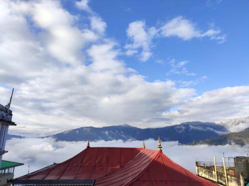 甘托克Hotel The Narayani Continental的红色帐篷享有云雾和山脉美景