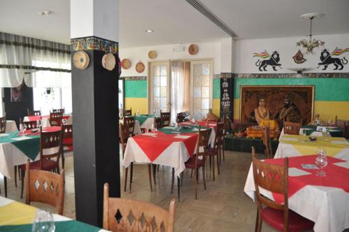 里乔内里戈贝罗酒店的餐厅设有桌椅,背景人员