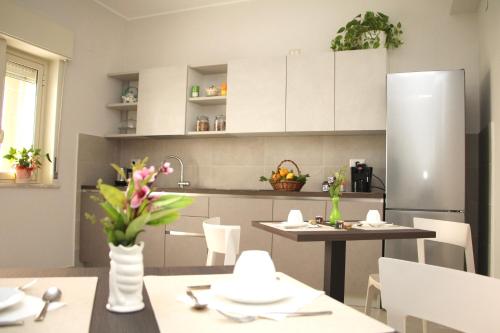 墨西拿B&B Delle Serre的厨房配有白色橱柜、桌子和冰箱。