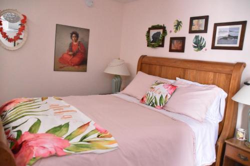 皮克图Seabank House Bed and Breakfast Aloha的一间卧室配有一张带粉红色棉被的床