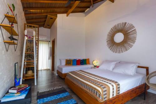 帕拉蒂Canto do Ilé Dive & Lodge的一间卧室设有两张床,墙上设有一面镜子