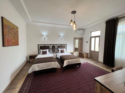 撒马尔罕The Loft Guest House的一间带两张床的卧室和红色地毯