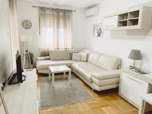 波德戈里察Aurora Apartment的白色的客厅配有沙发和桌子