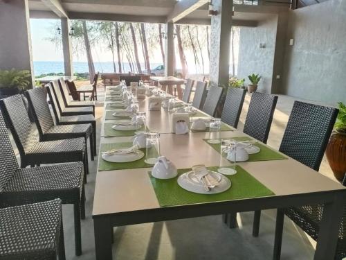 沙敦The Chevalley Beach Resort的一张长桌,上面有盘子和餐巾