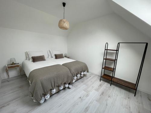 BouaflesL'histoire d'une hirondelle的白色卧室设有一张大床和镜子