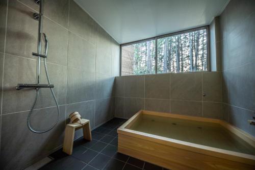 高山乌伯日黑丹诺莫里住宿加早餐旅馆的带浴缸的浴室和窗户。
