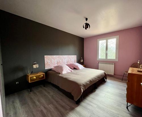 Villiers-Saint-BenoîtGîte à l’orée du pré的卧室配有一张带粉红色墙壁的大床
