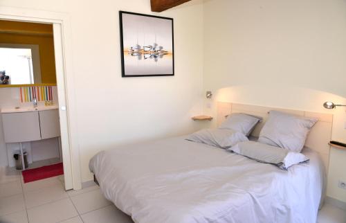 Marsillargues快乐山住宿加早餐旅馆的一间卧室配有带白色床单和枕头的床。