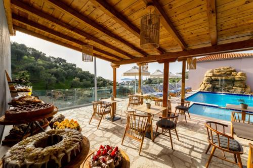 梅加利阿莫斯Skiathos Avaton Suites & Villas, Philian Hotels and Resorts的一个带游泳池和桌椅的庭院