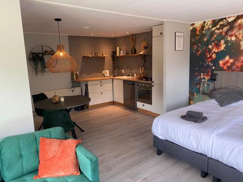 奥特罗De Veluwse bos Lodge的一间卧室配有一张床铺和一张桌子,还设有一间厨房