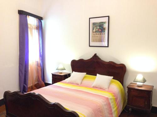 圣维森特Holidays Madeira的一间卧室配有一张大床、两张桌子和两盏灯。