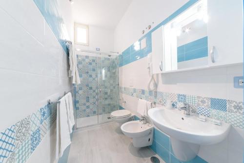 普罗奇达Hotel Celeste的蓝色和白色的浴室设有水槽和卫生间