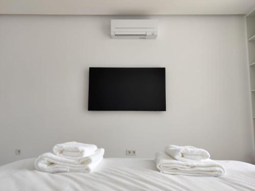 圣罗克Barrocas Villas Azores的一张带两张毛巾的床和一台电视