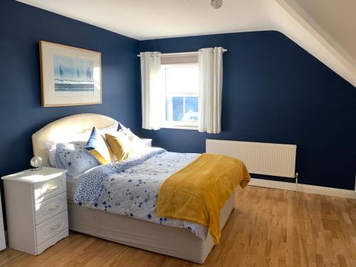 贝尔马利特Seascape on the edge of town: 4 beds all ensuite.的蓝色的卧室设有床和窗户