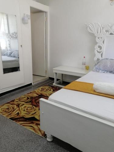 蒙巴萨Golden Nest的一间卧室配有一张床和玫瑰地毯