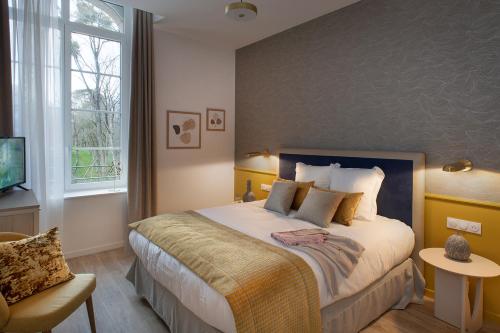 瓦讷DOMITYS - Manoir Maison Douaud的一间卧室设有一张大床和一个窗户。