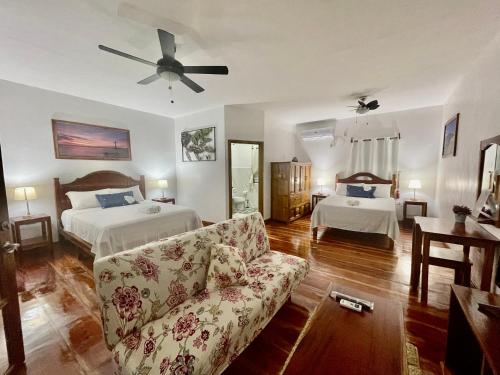 曼巴豪Agoho Resort的一间带两张床和一张沙发的客厅