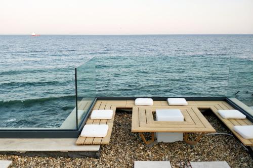 瓦尔纳Beach Villa Varna - cosiness 4 meters from the sea的一张桌子和椅子,背景是大海