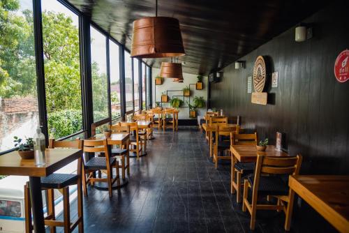 图斯特拉古铁雷斯Hotel Momotus的餐厅设有木桌、椅子和窗户。