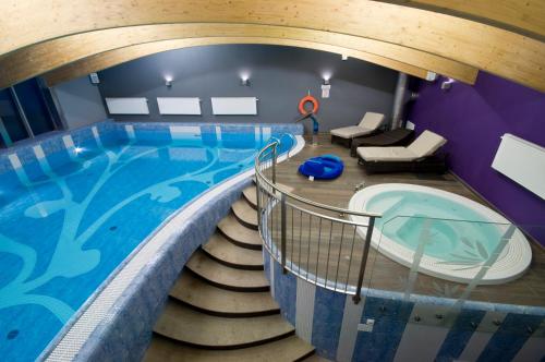 布拉涅沃Hotel Warmia Spa的一座带楼梯的大型游泳池,通往游泳池