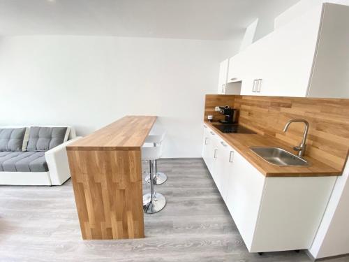 博维茨Apartment 3 Sovice的厨房配有白色橱柜和木制台面