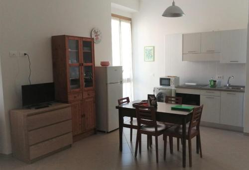 斯培西亚Casa Minù的厨房配有桌椅和冰箱。