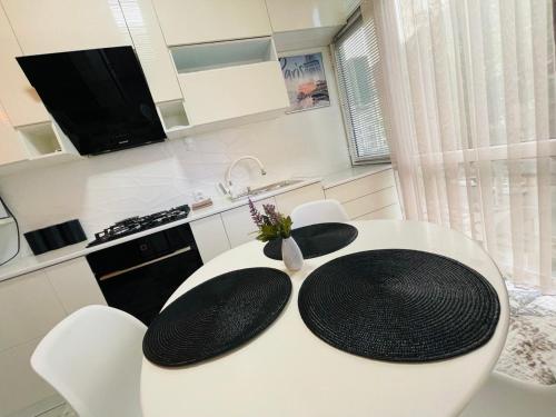 撒马尔罕Yas Apartment的白色的厨房配有白色的桌子和椅子