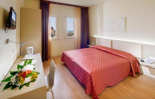 洛雷托圣弗朗西斯酒店的酒店客房,配有床和鲜花桌