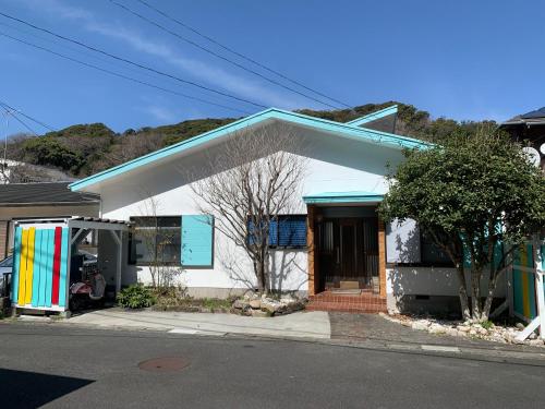 下田Ramjet Kisami Beach House Shimoda - Walk to the Beaches and BBQ!的一间白色的小房子,色彩缤纷