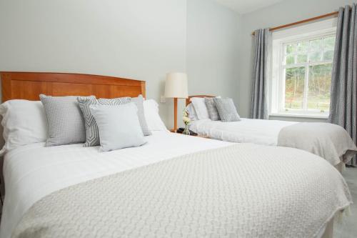 凯尔凯尔克兰洛奇酒店及休闲中心的一间卧室设有三张床、白色床单和窗户