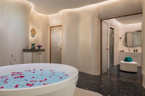 多哈Banyan Tree Doha At La Cigale Mushaireb的浴室配有装满红花的浴缸。