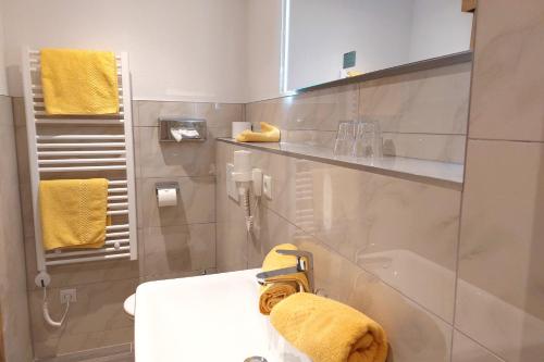 索尔登祖阿尔坦穆赫膳食公寓酒店的一间带水槽和黄毛巾的浴室