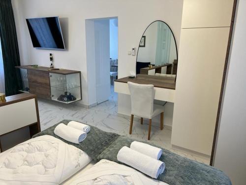 NašiceLa Luna Premium Deluxe Apartment with Free Jacuzzi, Bikes & Covered Parking的一间卧室配有一张床、一张书桌和一面镜子