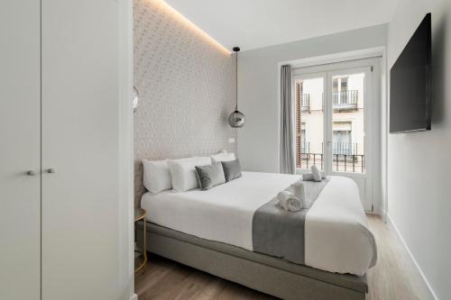 马德里Marco Polo Residence Hostal Boutique的白色的卧室设有一张大床和一个窗户