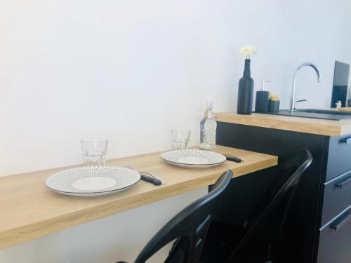 绍莱studio moderne et confortable Le nid的一个带两个盘子和玻璃的厨房台面